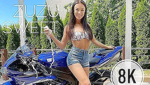 Brunette in a black dress takes a bike and rides it